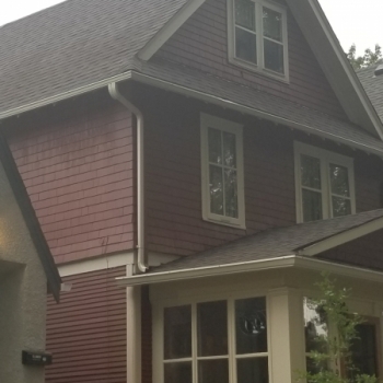 Installation of IKO Cambridge dual brown architectural shingles on this 2.5 story 12/12 pitch house. A nice accent to the red shake siding. 